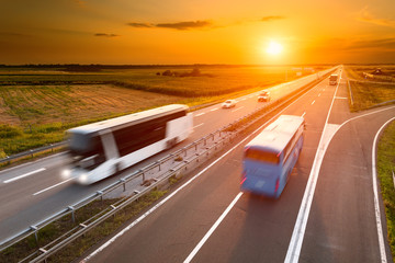 Two buses on highway in motion blur - obrazy, fototapety, plakaty