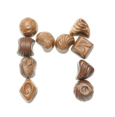 Alphabet letter M arranged from chocolate sweets isolated