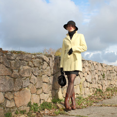 beautiful middle-aged woman in a yellow vintage coat,