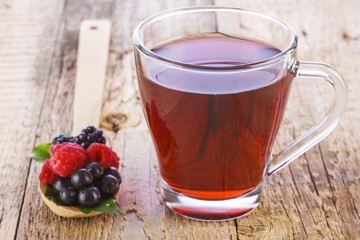 Fruit red tea with wild berries in wooden spoon