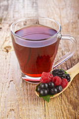 Fruit red tea with wild berries in wooden spoon