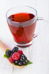 Fruit red tea with wild berries in wooden spoon