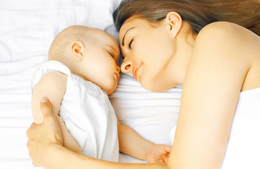Mother and baby sleep in bed together