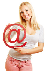 Frau hält at-Zeichen als Symbol für Internet