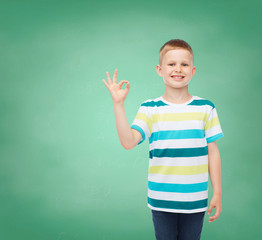 little boy in casual clothes making OK gesture