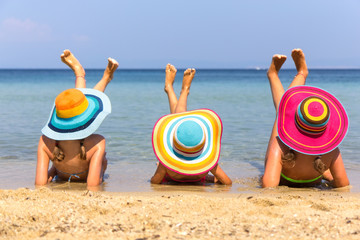 Girls with colorful hats on the beach
