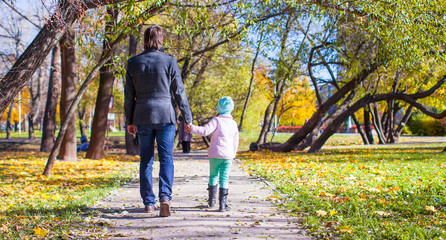 Fototapeta premium Young father and little girl walking in autumn park