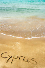 Cyprus written in sand on beach with sea in background