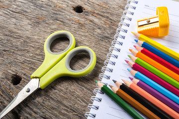 Blank paper and colorful pencils on the wooden table.