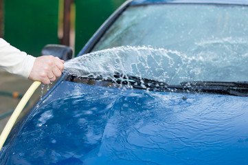The process of washing cars with a hose with water