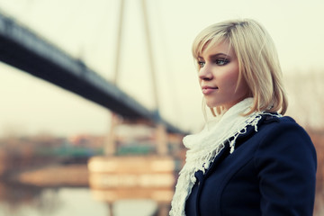 Fototapeta na wymiar Young blond fashion woman at the river bridge