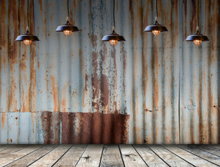 Empty room interior. Lamp hangs in rusted galvanized iron plate on background with wooded floor.  Free space for display or montage products.