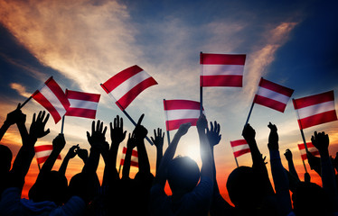Silhouettes of People Holding Flag of Austria