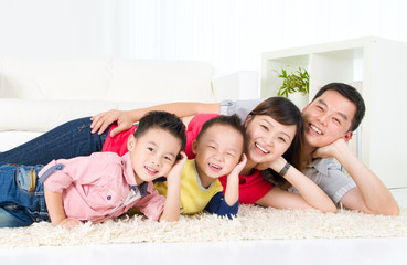 Asian family lying on the floor and smiling