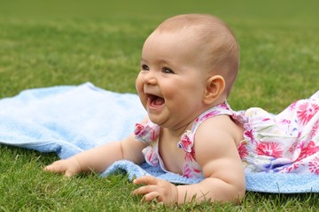 Baby, girl, seven-month-old child lying on a blue blanket