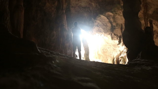 a man walked into the cave and looking at the light