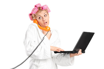 Surprised girl holding laptop and talking on phone