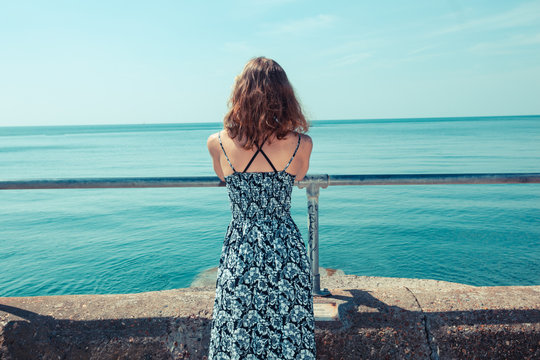 Young woman standing on a pier by the ocean