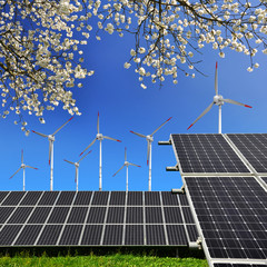Solar energy panels and wind turbines against blue sky
