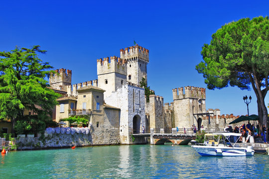 Panoramic view of Scaliger Castle in Sirmione on the shore of Lake Garda with medieval fortress and emerald water Lombardy Northern Italy