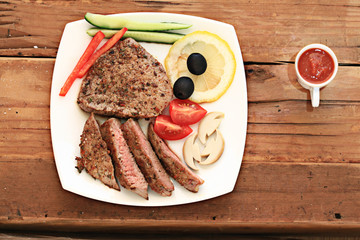 grilled meat on a plate serving rustic wooden background