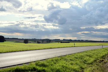Landstraße vor dramatischer Wolkenkulisse