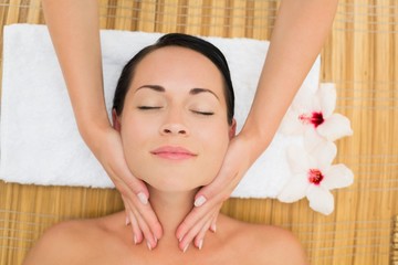 Peaceful brunette enjoying a facial massage