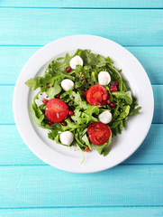 Green salad made with  arugula, tomatoes, cheese mozzarella