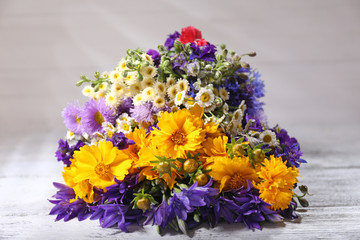 Beautiful wild flowers on wooden table