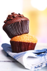 Tasty muffins on napkin, on bright background