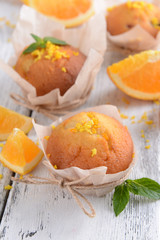 Tasty cupcakes with orange on table close-up