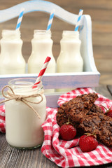 Milk in bottles with paper straws on table