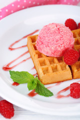 Tasty belgian waffles with ice cream on wooden table