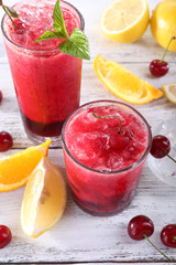 Fresh cold cherry cocktail with mint, ice and lemon