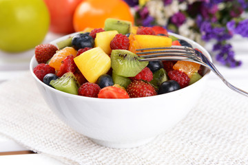 Delicious fruits salad in plate on table close-up