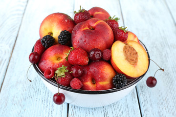 Naklejka na ściany i meble Peaches and berries in bowl on table