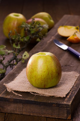 Apples red and green, partly sliced, Äpfel auf hölzernem Brett