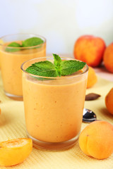 Apricot dessert in glasses on table on bright background