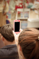 Young woman taking a photo with her phone