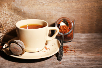 Cup of tasty rooibos tea, on wooden table