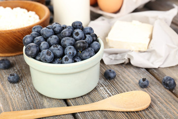 Fresh blueberries and milk products on wooden table