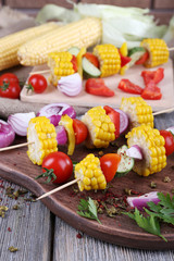 Sliced vegetables on picks on board on table close-up
