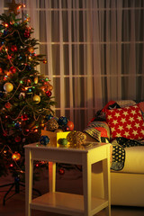 Decorated Christmas tree on home interior background at night