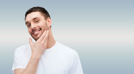 beautiful smiling man touching his face