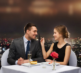 smiling couple eating dessert at restaurant