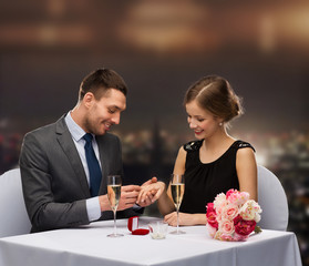 man proposing to his girlfriend at restaurant