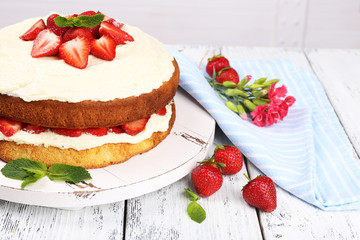 Delicious biscuit cake with strawberries on table close-up