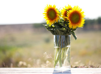 Beautiful sunflowers on table on bright background