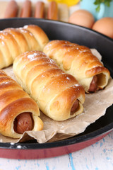 Baked sausage rolls in pan on table close-up