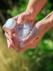 woman crushing a plastic bottle